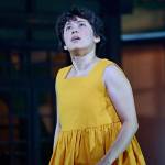 Satsuki (Ami Okumura Jones) wearing a yellow dress and looking up.